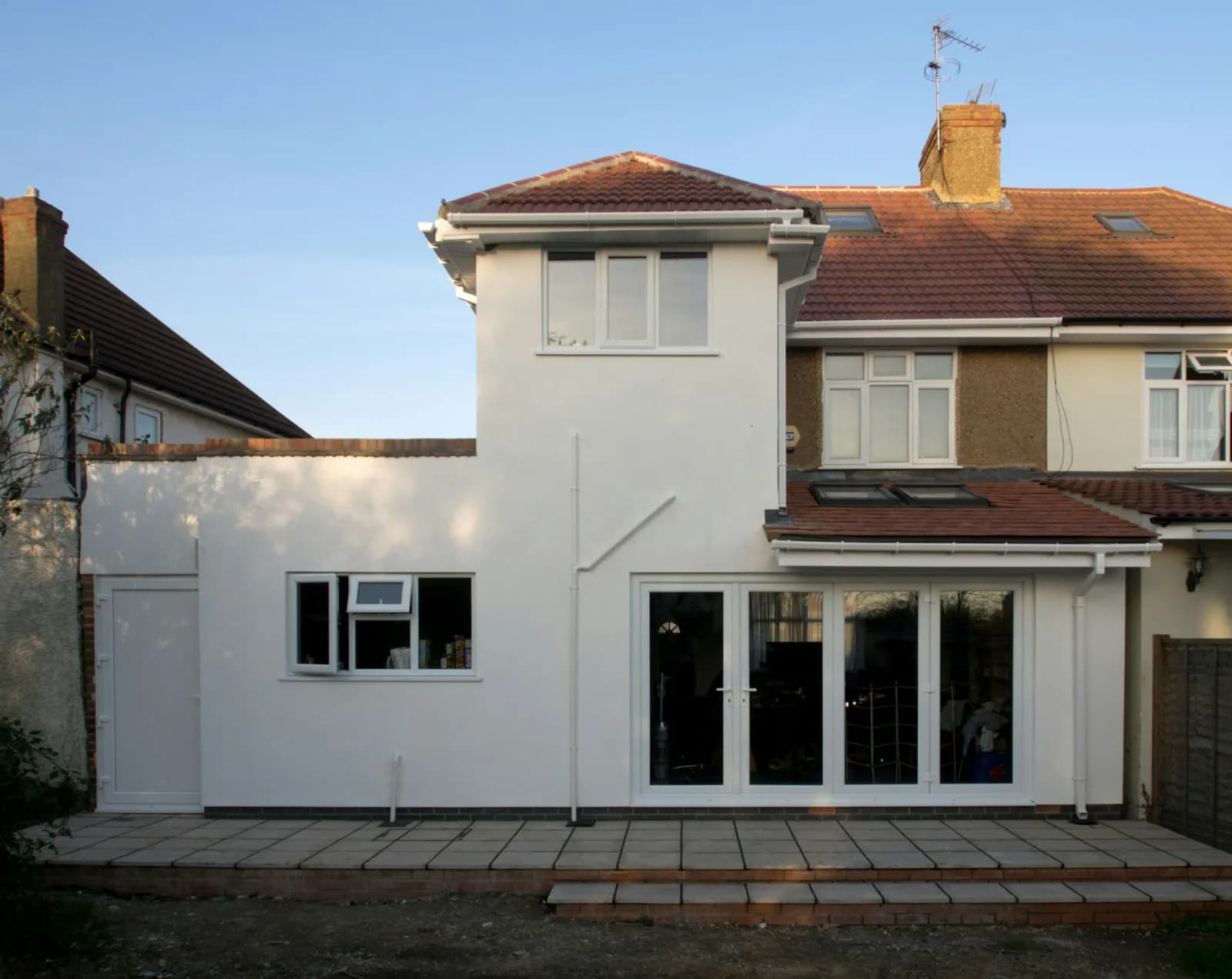 A rendered single-storey rear extension with bi-fold doors onto a patio