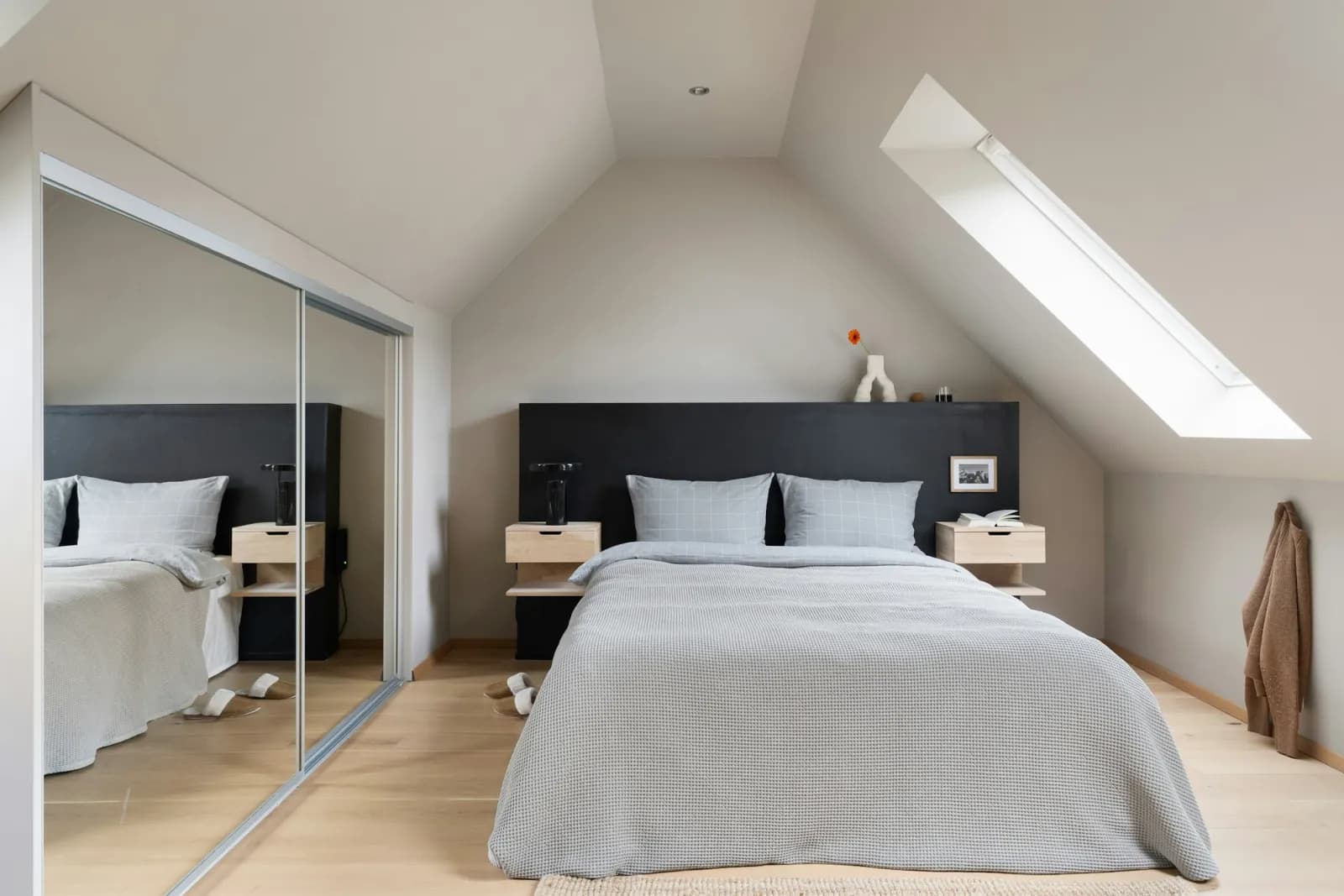 A converted loft bedroom with roof windows and fitted wardrobes